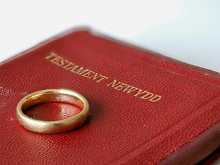 selected focus Gold wedding ring on Welsh New Testament bible