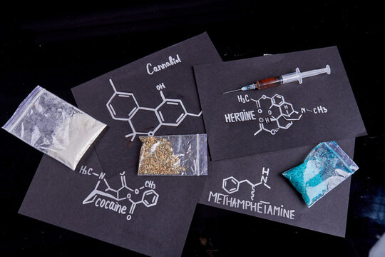 Top view drugs molecules and plastic packs isolated on black background. Methamphetamine cocaine heroine and cannabiol.