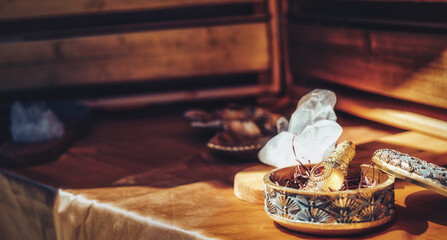 ornamental bottle of perfume and cristal on a wooden background.