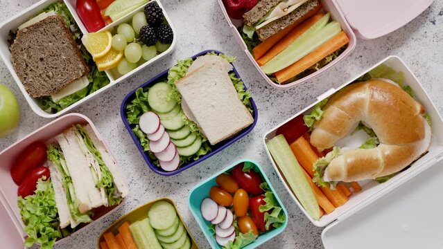 Shot of school lunchboxes with various healthy nutritious meals on stone background