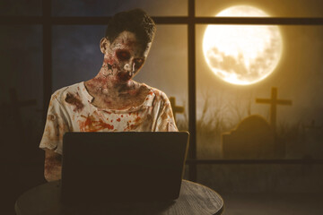 Male ghost using a laptop near the window
