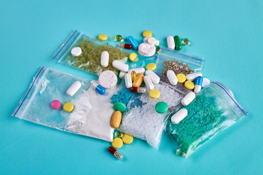 Pile of various drugs on blue background top view. Pills with tablets and capsules.