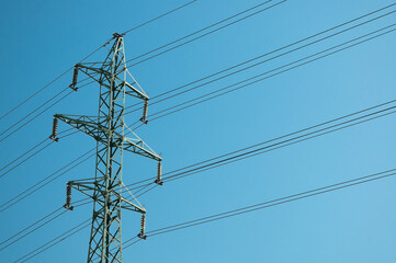 a high-voltage power transmission line, in the photo, a power line support against a blue sky