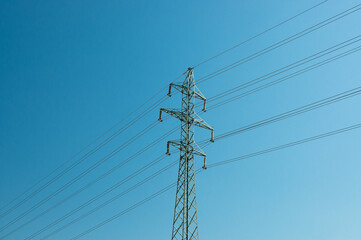 a high-voltage power transmission line, in the photo, a power line support against a blue sky