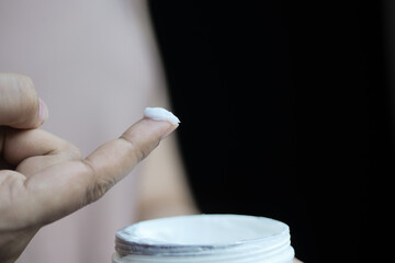 woman applying beauty cream onto skin at home top view 
