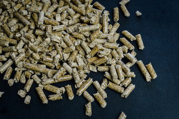 group of wood pellets for heating on a dark background with space for text