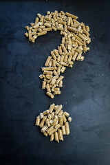 question mark drawn by wood pellets, concept to illustrate the unknown of the price increase also...