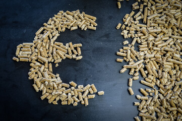 euro currency symbol drawn with wood pellets for heating, concept to illustrate the unknown of the...