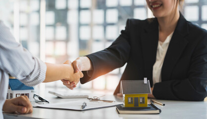 Successful deal Real estate lease or home purchase concept buyer shakes hands with bank employee after office contract is completed.