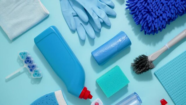 Colorful cleaning products on plain blue background. Housecleaning concept