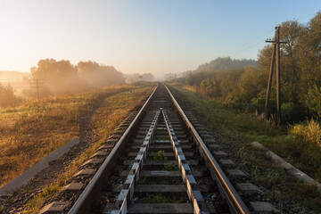 Landscape with railway. Sunrise over the misty river