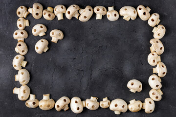 Frame of raw champignon mushrooms in the form of skulls. Edible Halloween Concept