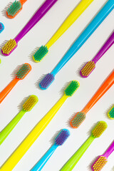 Photo of a modern colorfull toothbrush with differ colors like yellow, violet, blue, green on a white background and marble background flat lay style in studio 