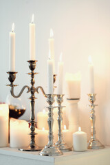 Burning candles on a white wall background