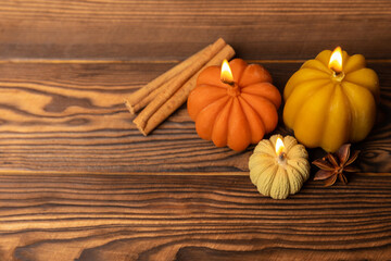 Fototapeta premium Autumn composition.Pumpkin candles,spicy star anise spices and cinnamon on a brown wooden background.Cozy home decor.Halloween concept.Happy Thanksgiving.Flat lay.Copy space.