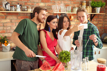 Get the party started with this fun and vibrant stock photo of a group of people enjoying food and drinks in the kitchen.