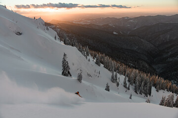 Gorgeous view of winter mountain landscape and freerider skiing down the snowy slope
