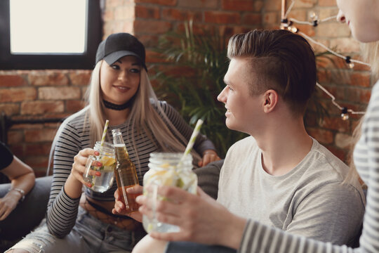 Get the party started with this fun and vibrant stock photo of a group of people enjoying food and drinks in the kitchen