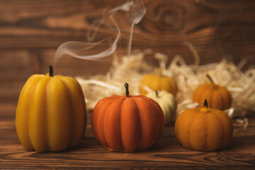 Autumn composition.Pumpkin candles,spicy star anise spices and cinnamon on a brown wooden background.Cozy home decor.Halloween concept.Happy Thanksgiving.Flat lay.Copy space.
