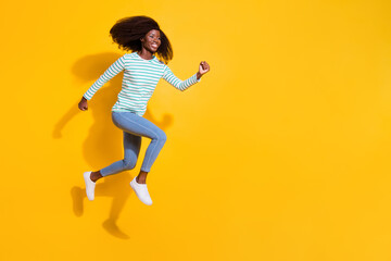 Fototapeta na wymiar Full length profile portrait of excited sportive person look running jump empty space isolated on yellow color background