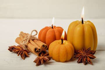 Autumn composition.Pumpkin candles,spicy star anise spices and cinnamon on a white wooden background.Cozy home decor.Halloween concept.Happy Thanksgiving.Flat lay.Copy space.