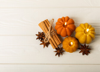 Autumn composition.Pumpkin candles,spicy star anise spices and cinnamon on a white wooden background.Cozy home decor.Halloween concept.Happy Thanksgiving.Flat lay.Copy space.