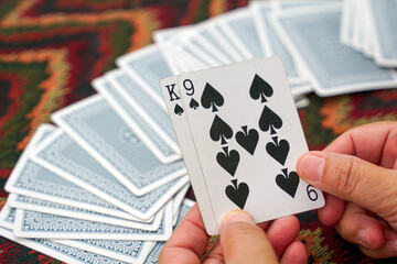 Asian card players play poker with friends at leisure. Get the King of Spades and the 9 of Spades, the winner of the game. Soft and selective focus.