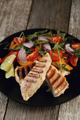Savor the Flavor: Smoked Chicken and Salad on a Dark Wooden Background, a Perfectly Delicious Combination