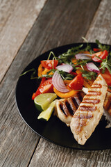 Savor the Flavor: Smoked Chicken and Salad on a Dark Wooden Background, a Perfectly Delicious Combination