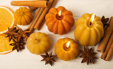 Autumn composition.Pumpkin candles,spicy star anise spices and cinnamon on a white wooden background.Cozy home decor.Halloween concept.Happy Thanksgiving.Flat lay.Copy space.