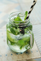 Mojito cocktail with lime and mint in highball glass on a grey on background
