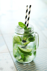 Mojito cocktail with lime and mint in highball glass on a grey on background