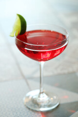 Cocktail drink on a old wooden board. Alcoholic beverage with tropical fruits red pepper herb and ice.