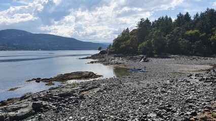 Kayaks and canoe on pebble beach on Vancouver Island