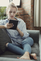 Obraz premium Woman working at home on her tablet
