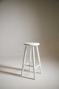 White stool with shadow on white background. Location in studio with tabouret on white background