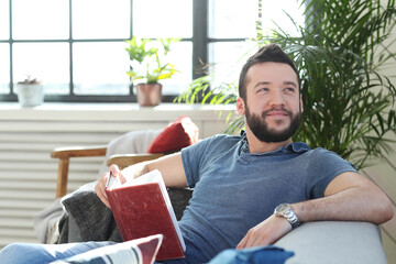 Handsome young man with beard using laptop at home