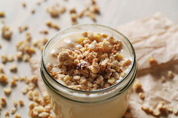 Homemade cooked healthy granola for breakfast in a wooden bowl on the table and near a bottle of milk. Place for text. Fitness food, snack