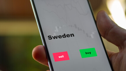 An investor's analyzing the Sweden etf fund on screen. A phone shows the ETF's prices Swedish to invest