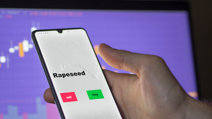An investor's analyzing the rapeseed etf fund on screen. A phone shows the ETF's prices food commodities to invest