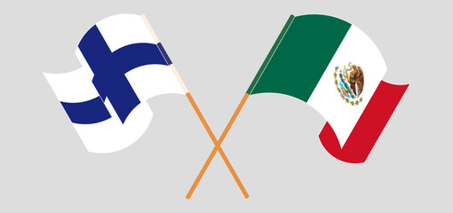 Crossed and waving flags of Finland and Mexico