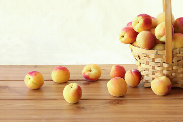 Apricots in wicker basket and scattered on the table isolated on white