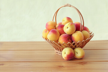 Apricots in wicker basket on the table isolated on white