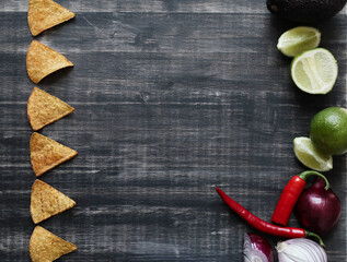 Collection of mexican nachos chips with red hot chilli peppers on wooden background