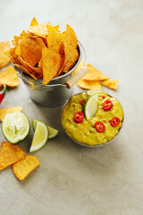 Spicy Guacamole With Tortilla Chips and Fresh Ingredients on a Table