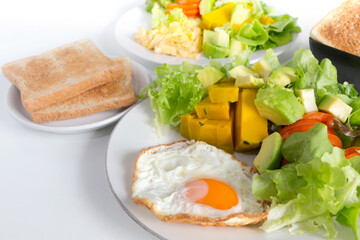 Breakfast. Fried eggs, toasts and salad avocado,tomato,green oak and pumkin. Healthy food concept.