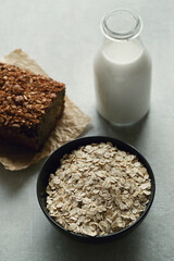 View from above on whole grain bread with oatmeal flakes in bowl and glass of milk 