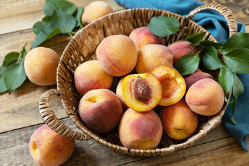 Naklejka na ściany i meble Fall harvest background. Organic fruits. Farmer's market. Basket of ripe peaches on a rustic wooden table.