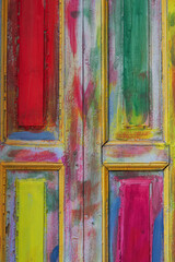 Multi-colored painted real wooden door background with a pastel palette.