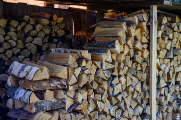 A woodpile stored for the winter for the furnace under the canopy